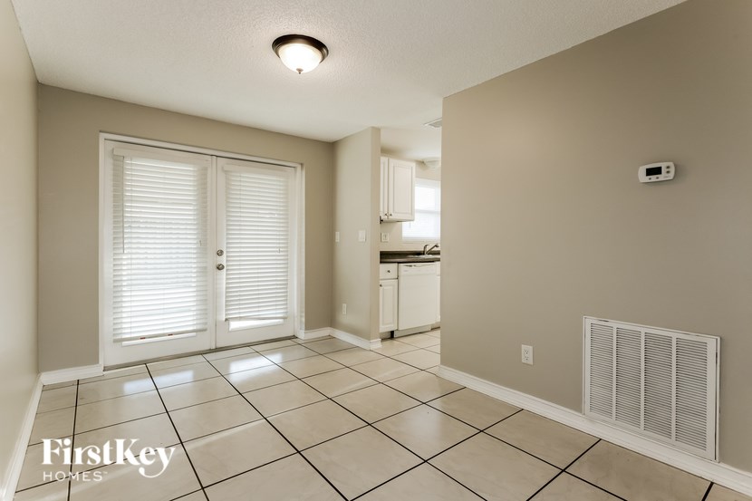 A room with a tile floor and a window with blinds.