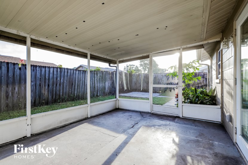 A patio with a wooden ceiling and white walls.