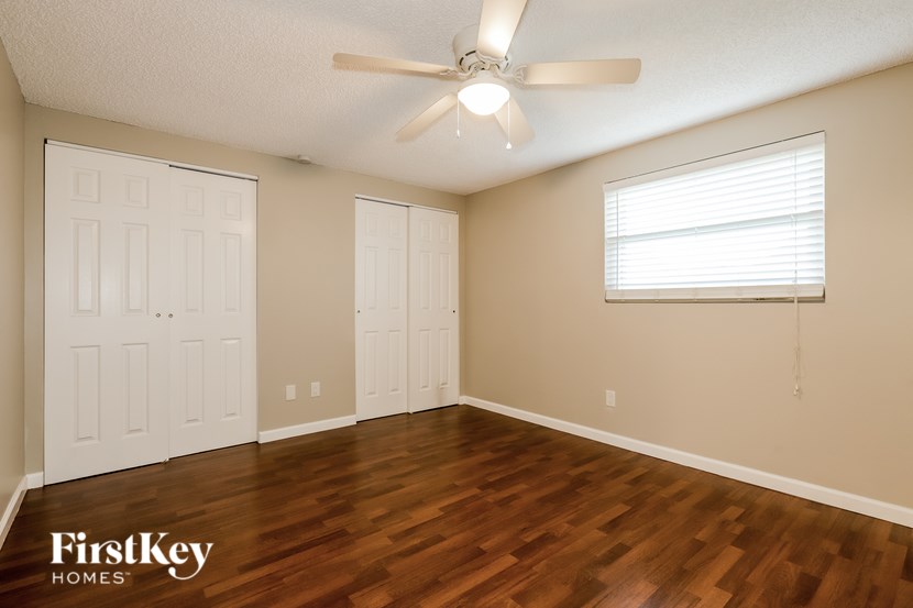 A room with wooden floors and a ceiling fan.