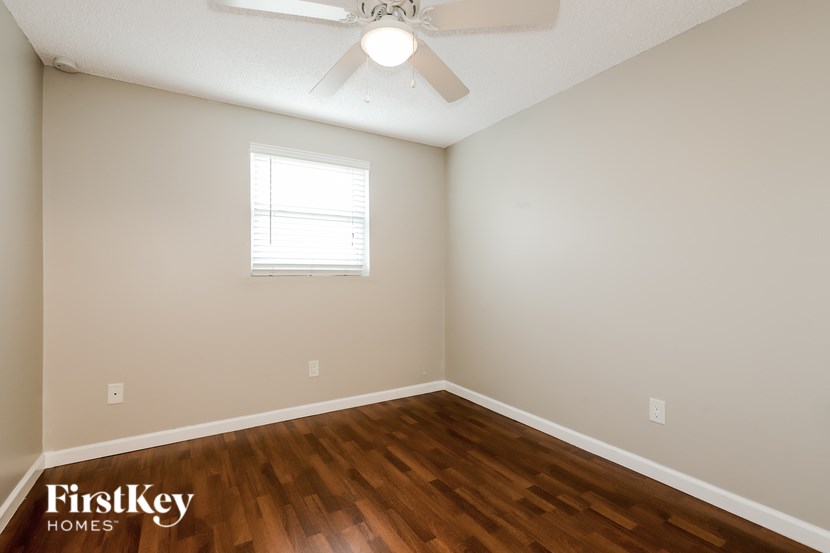 A room with a ceiling fan and a window.