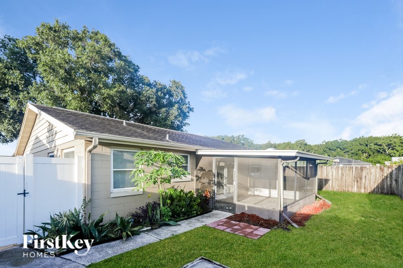 A house with a white fence and a small garden in front.