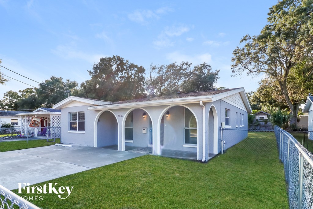 a blue and white house with a porch and a lawn