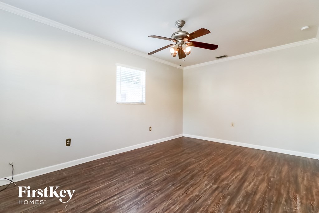 the living room of an empty house with a ceiling fan