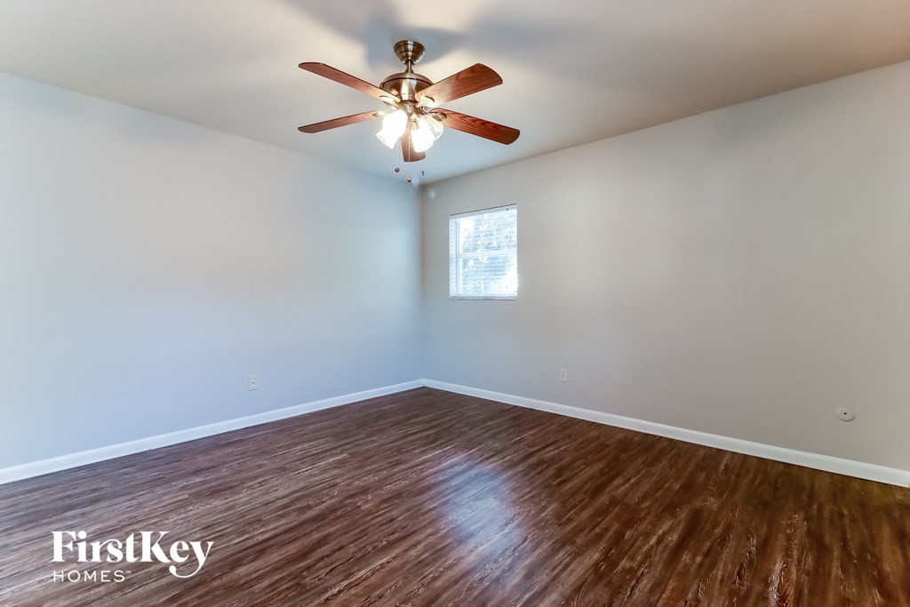 a living room with a ceiling fan and wood floors