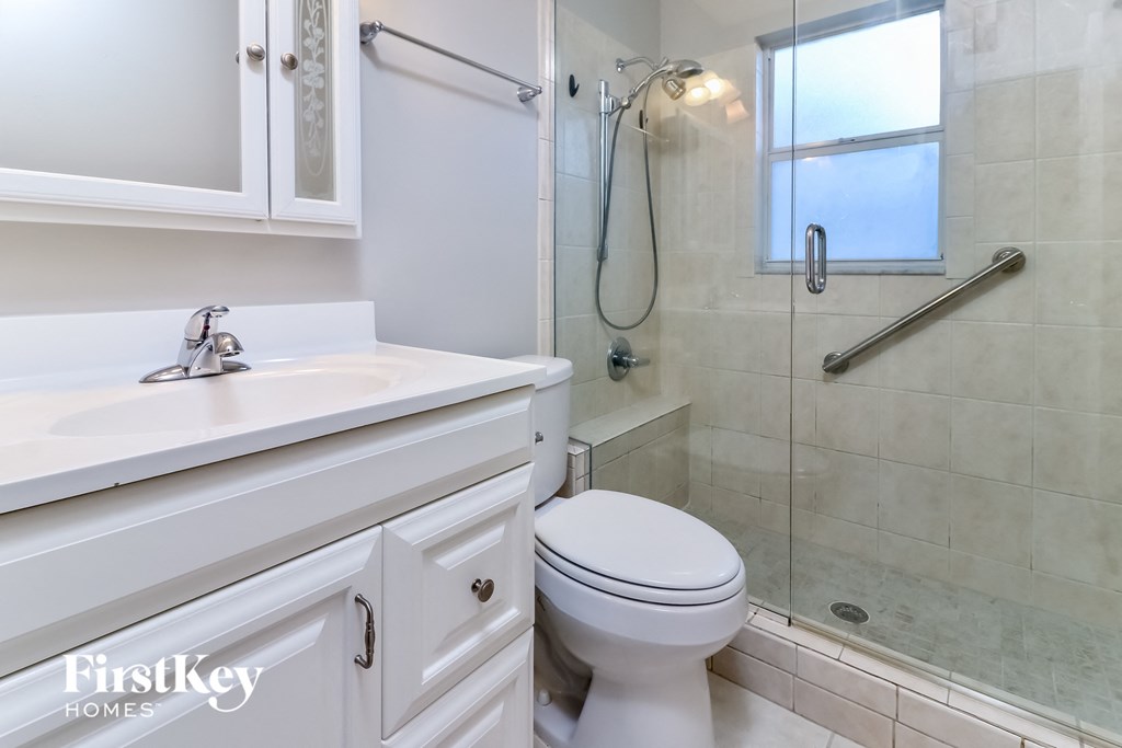 a bathroom with a shower and a sink and a toilet