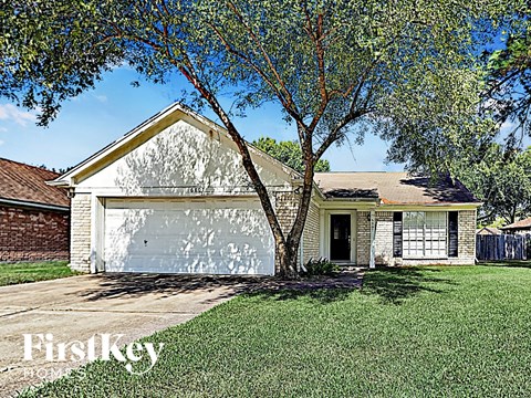 a small white house with a tree in the yard