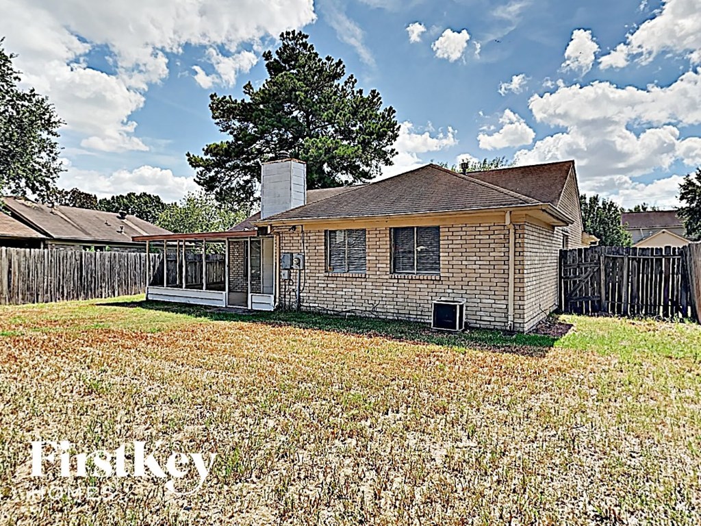the backyard of a small house with a yard and a fence