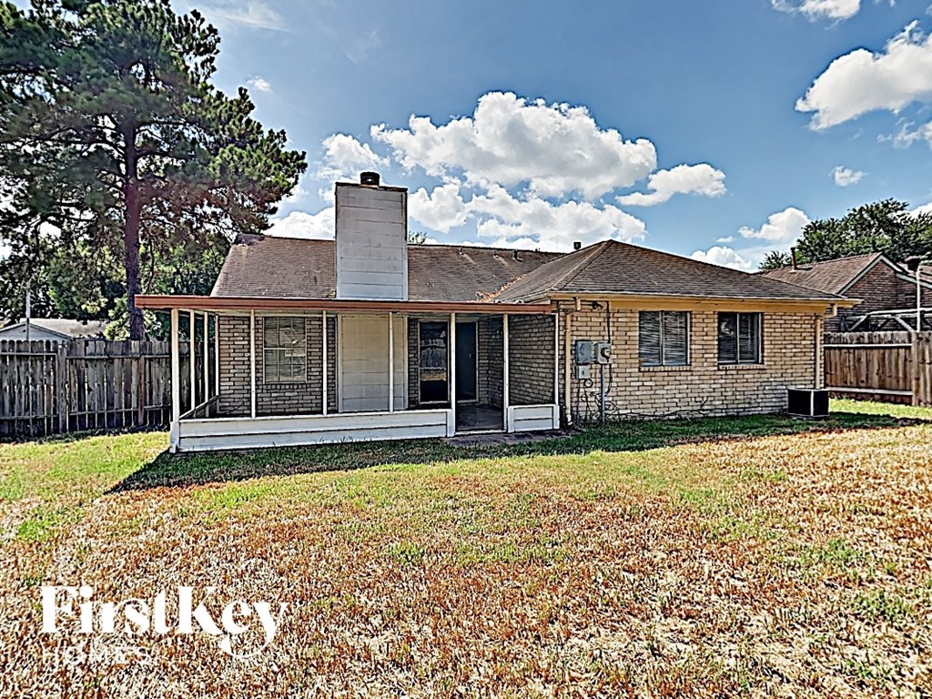 the front of a house with a yard and a fence