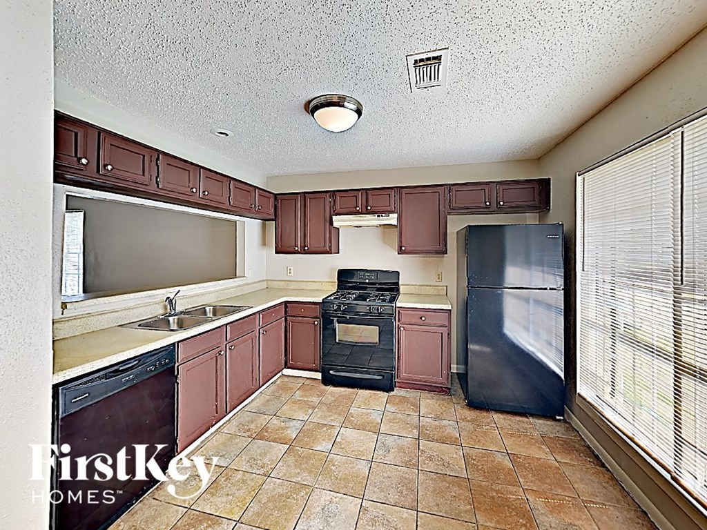 a kitchen with a stove refrigerator and a sink