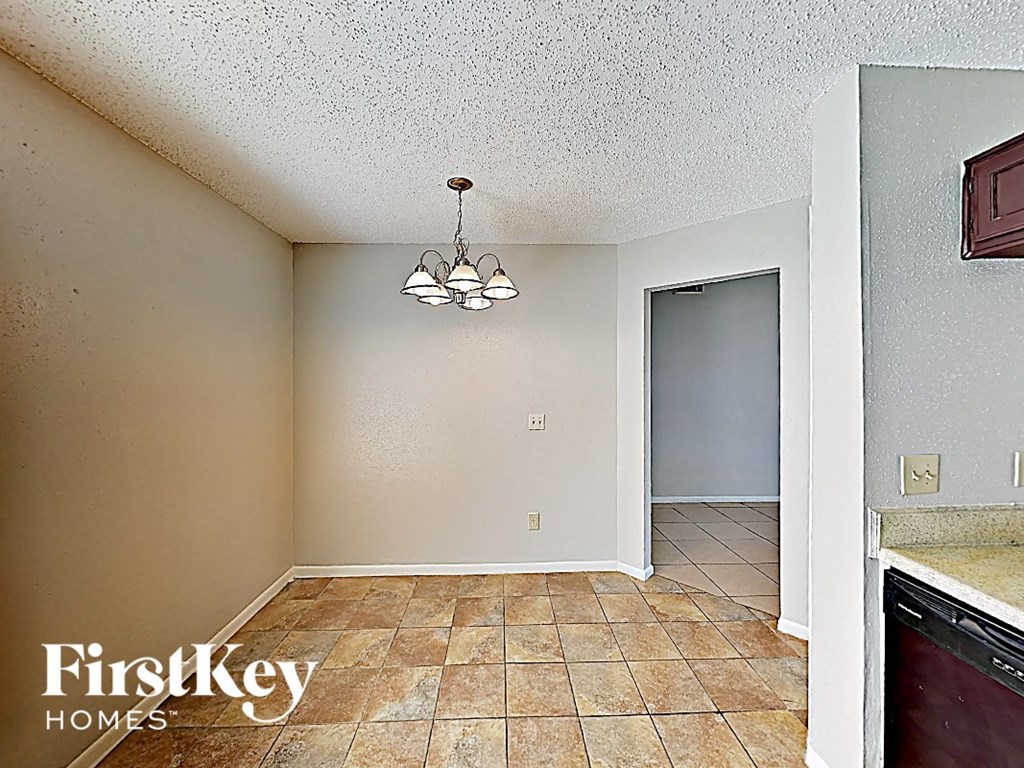 an empty kitchen and living room with a door to the bathroom
