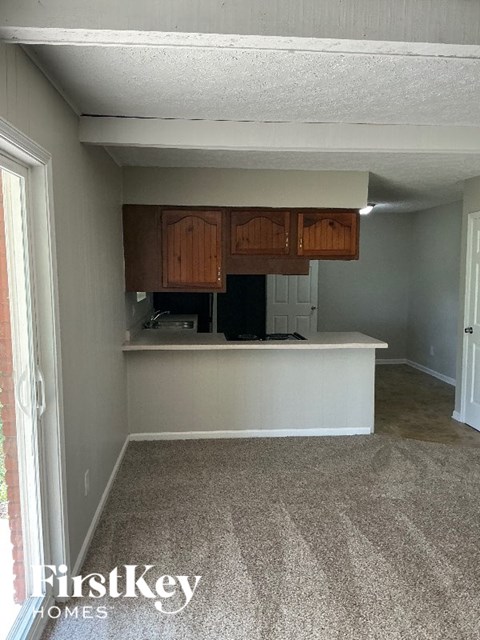 A kitchen area with a white counter and brown cabinets.