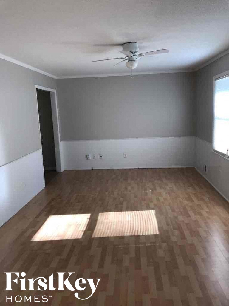 A room with wooden flooring and a ceiling fan.