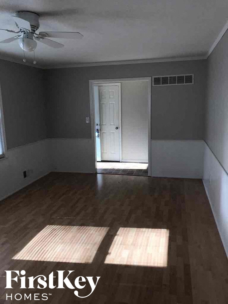 A room with wooden floors and a ceiling fan.