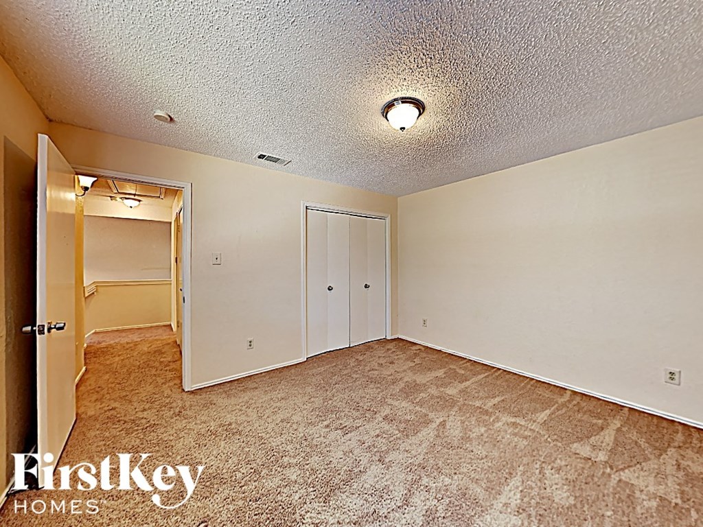an empty bedroom with a closet and a door to a bathroom