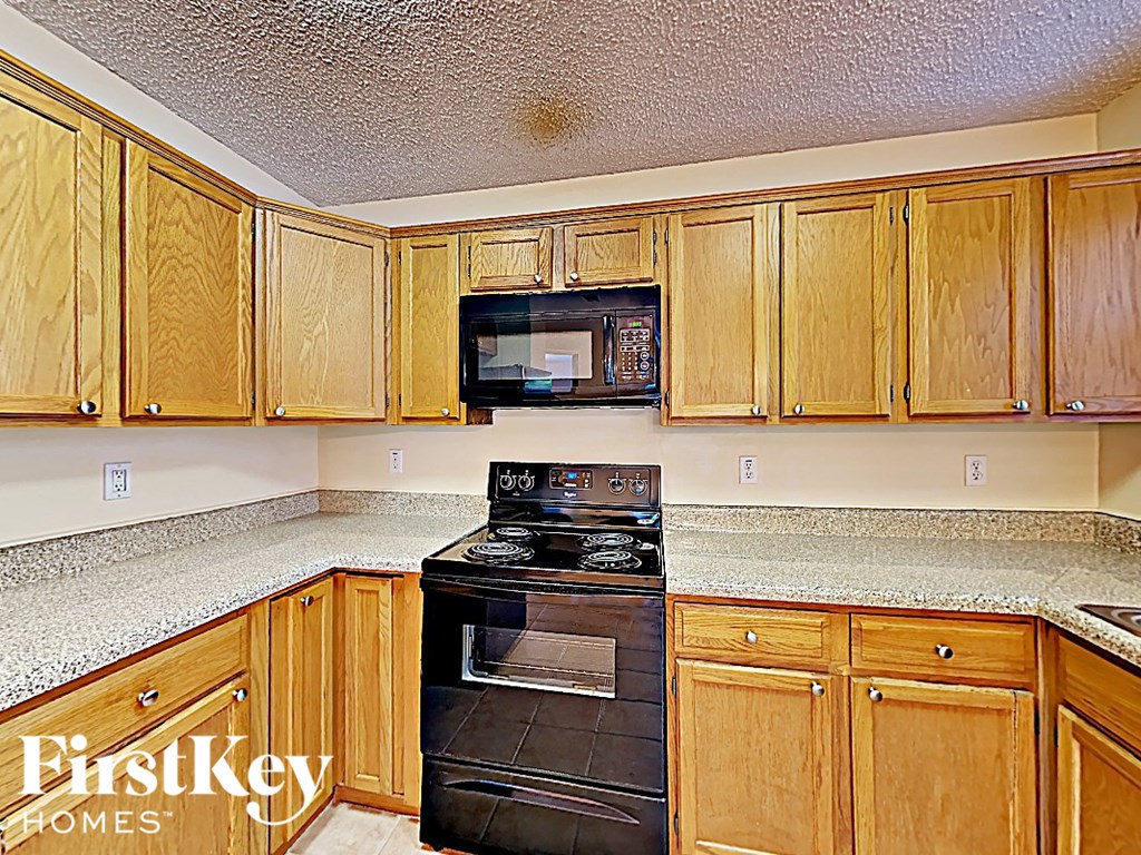 a kitchen with black appliances and wood cabinets