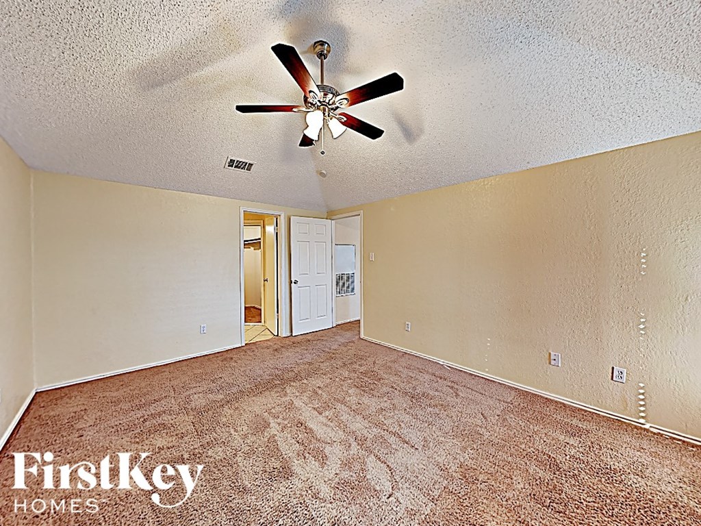 the living room of an empty house with a ceiling fan