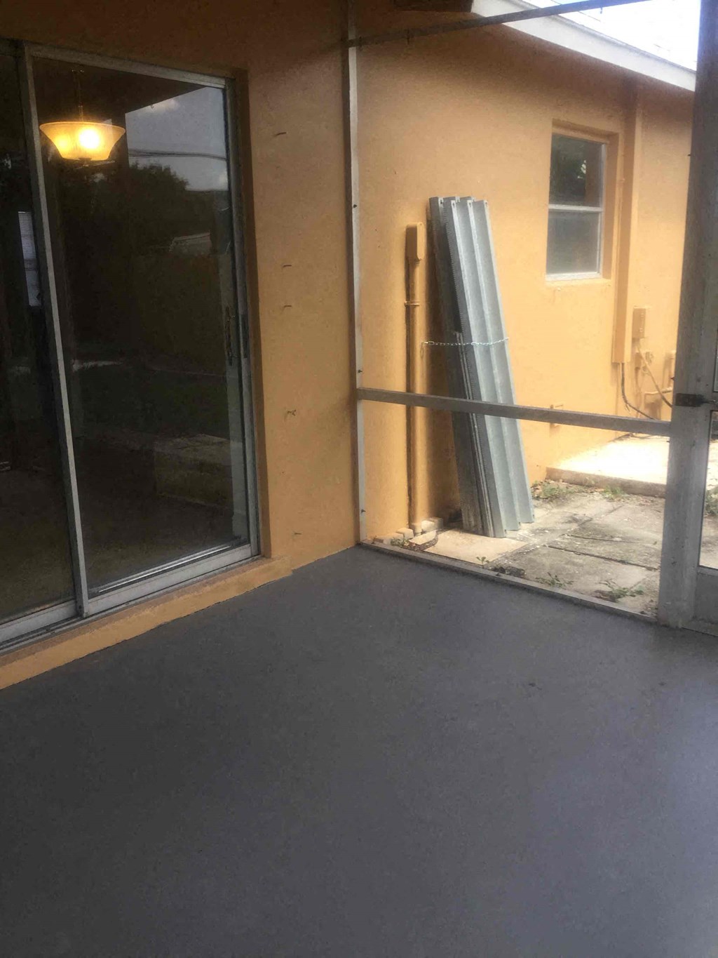 A room with a sliding glass door and a window.