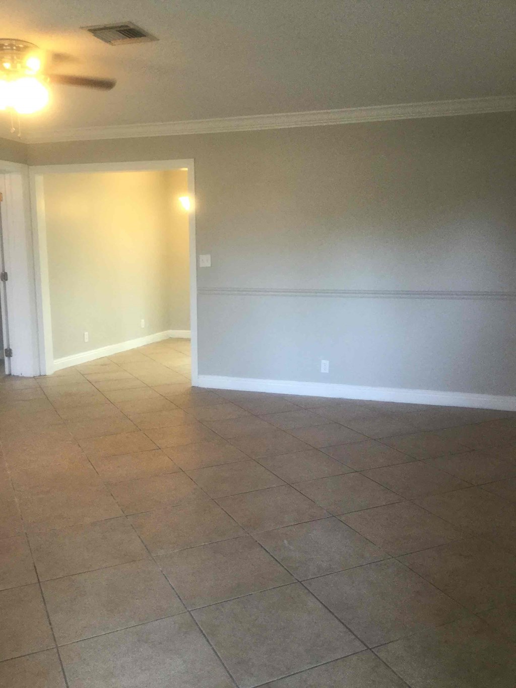A room with tile flooring and a ceiling fan.