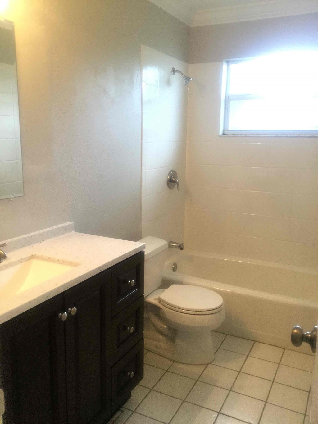 A white toilet sits in a bathroom next to a bathtub.