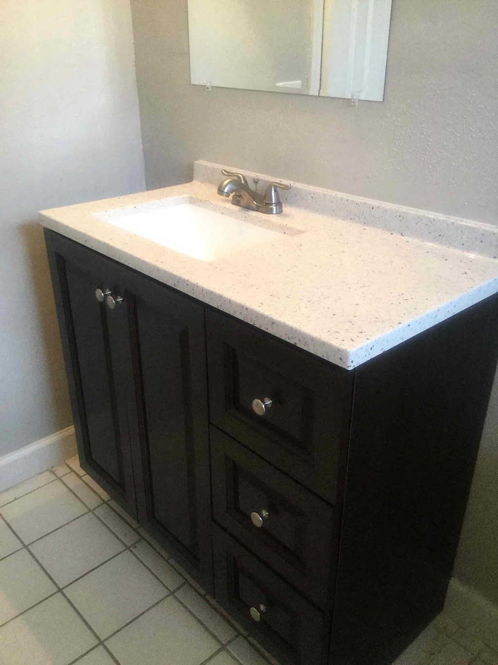 A bathroom vanity with a sink and a mirror.