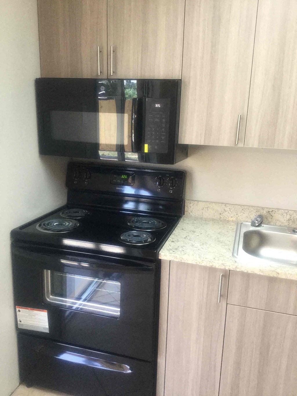 A black stove and microwave in a kitchen.