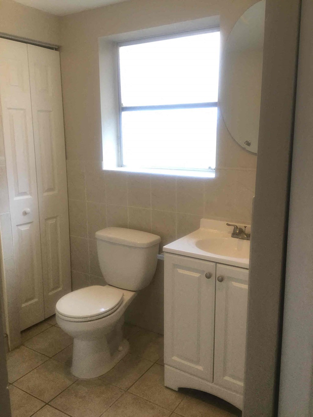 A white toilet and sink in a bathroom.