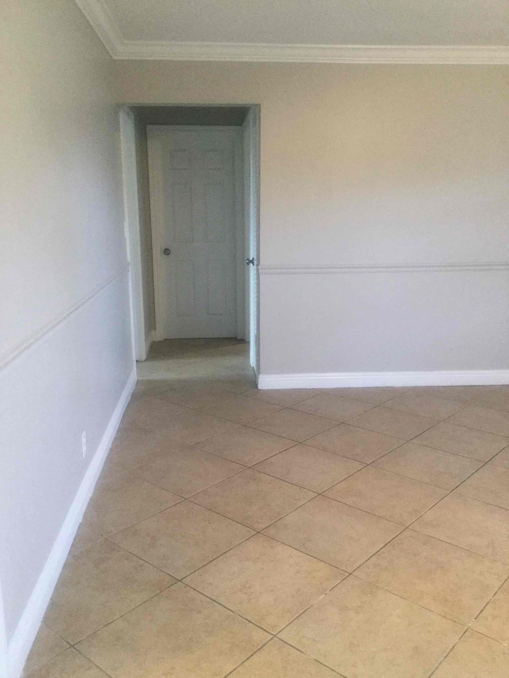 A room with a door and tiled floor.