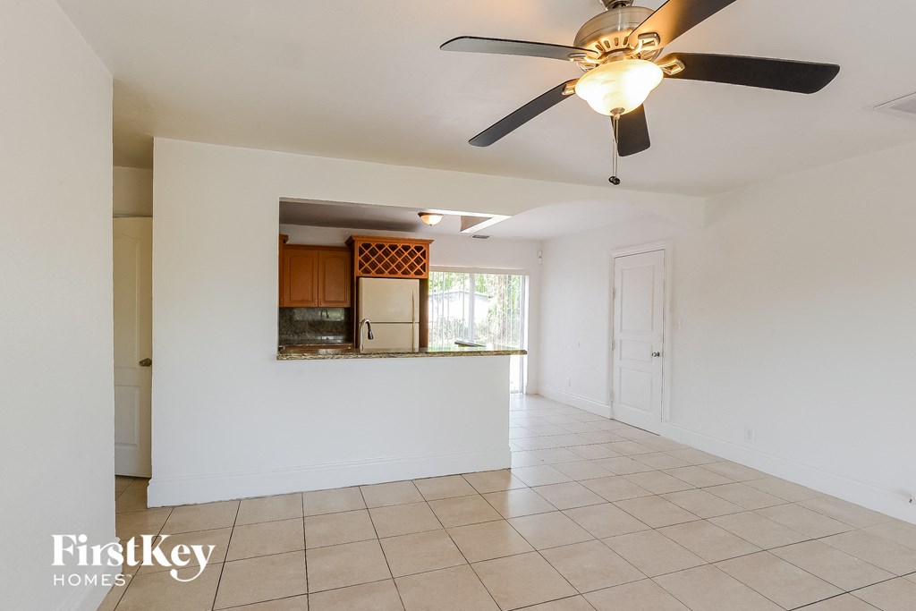 A spacious room with a ceiling fan and tiled flooring.