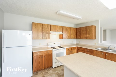 a kitchen with white appliances and wooden cabinets