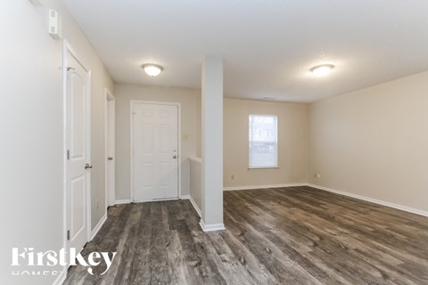 A room with wooden flooring and white walls.