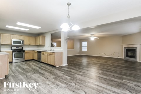 A spacious kitchen with wooden cabinets and a grey floor.