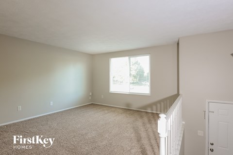 a bedroom with a white carpeted floor and a window