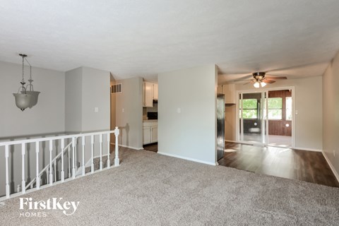 the living room and dining room with the kitchen in the background