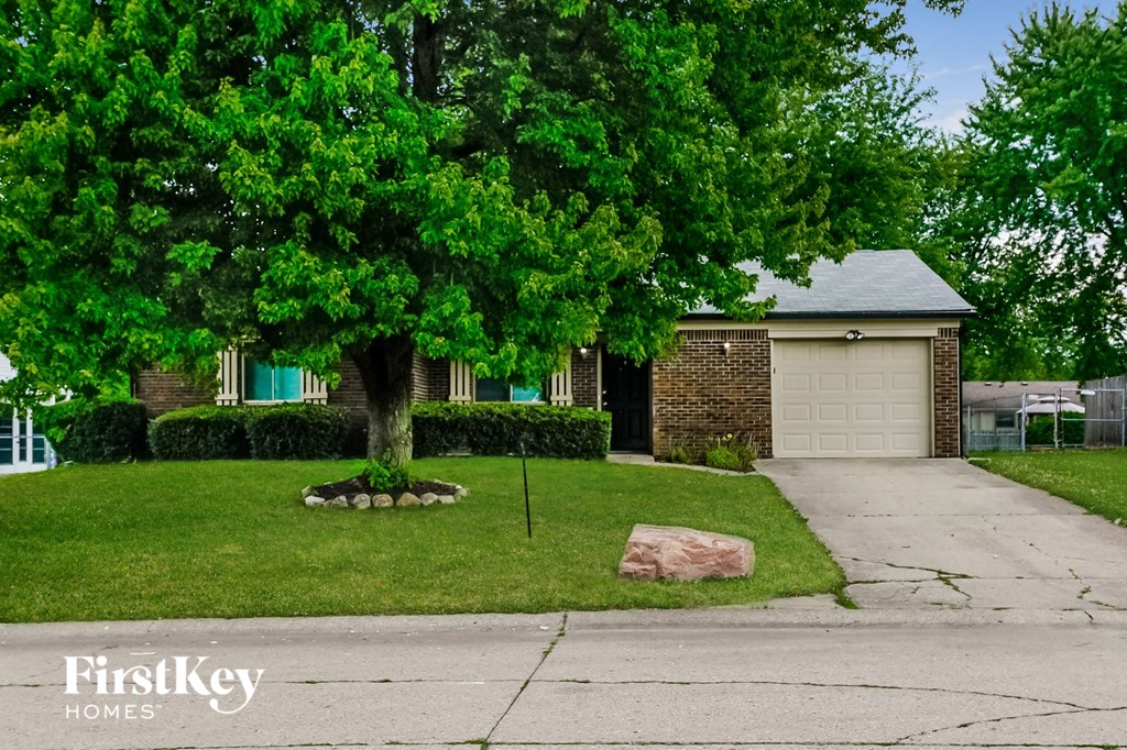 a tree in a yard in front of a house