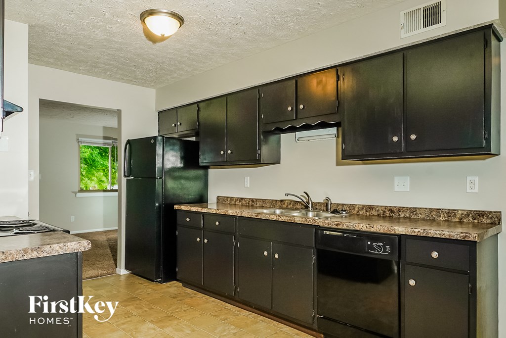 a kitchen with black cabinets and a black refrigerator