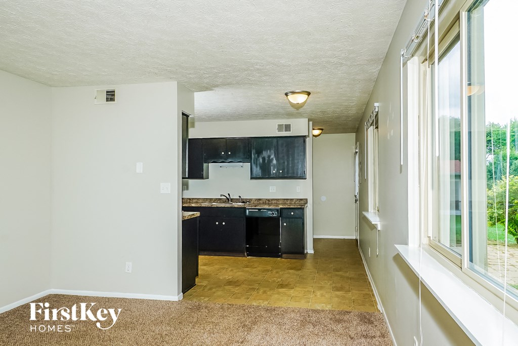 a kitchen with black cabinets and a black stove and a window