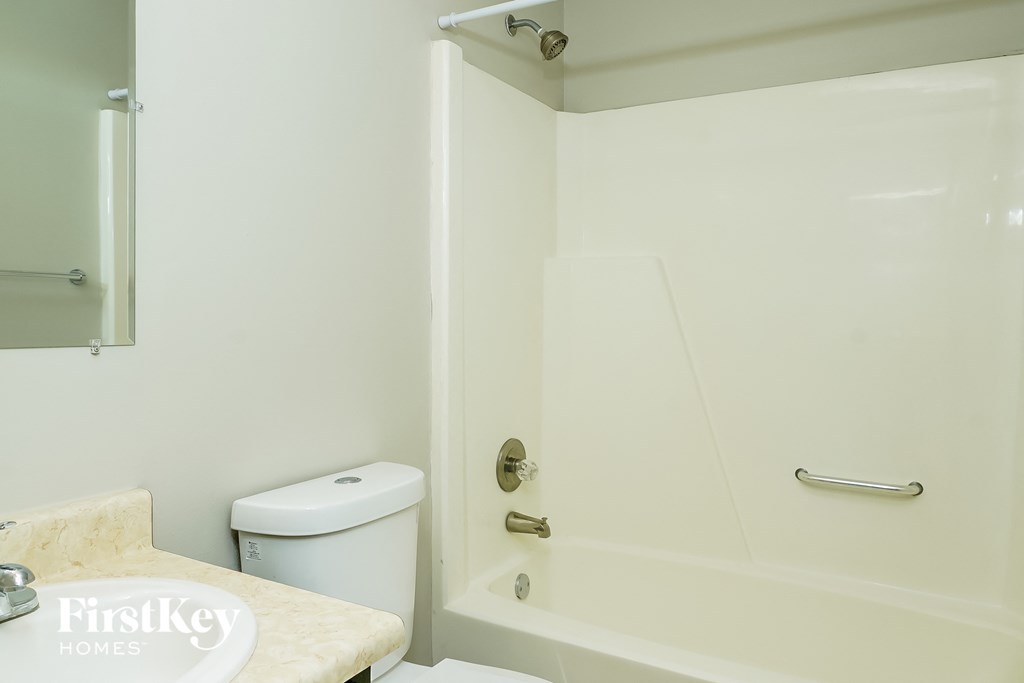 a bathroom with a shower and a toilet and a sink
