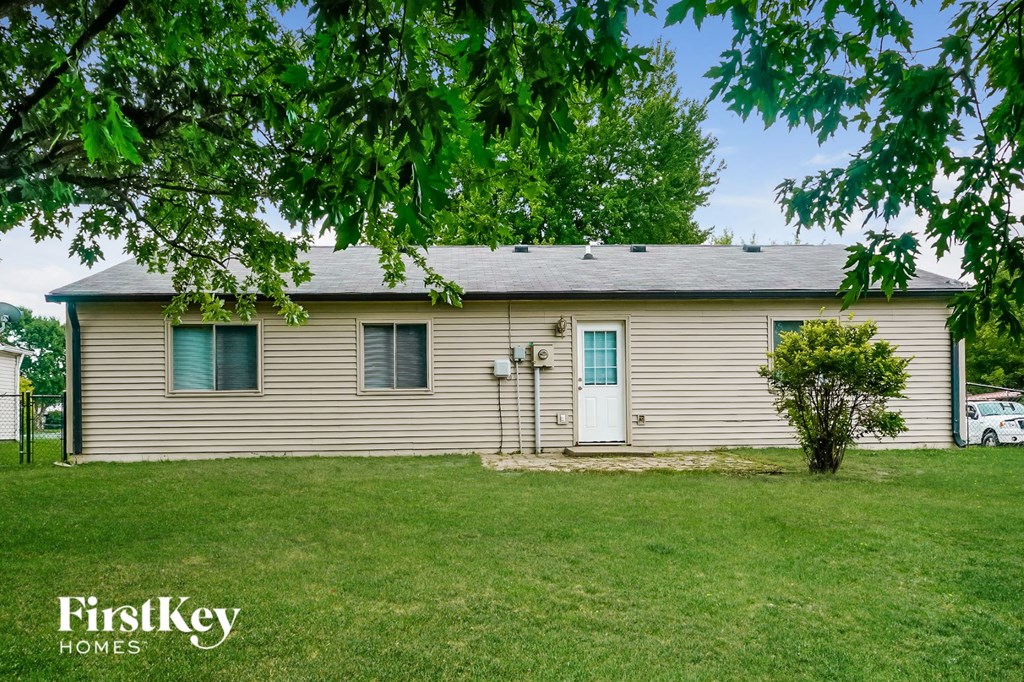 a white house with a blue door on a grass field
