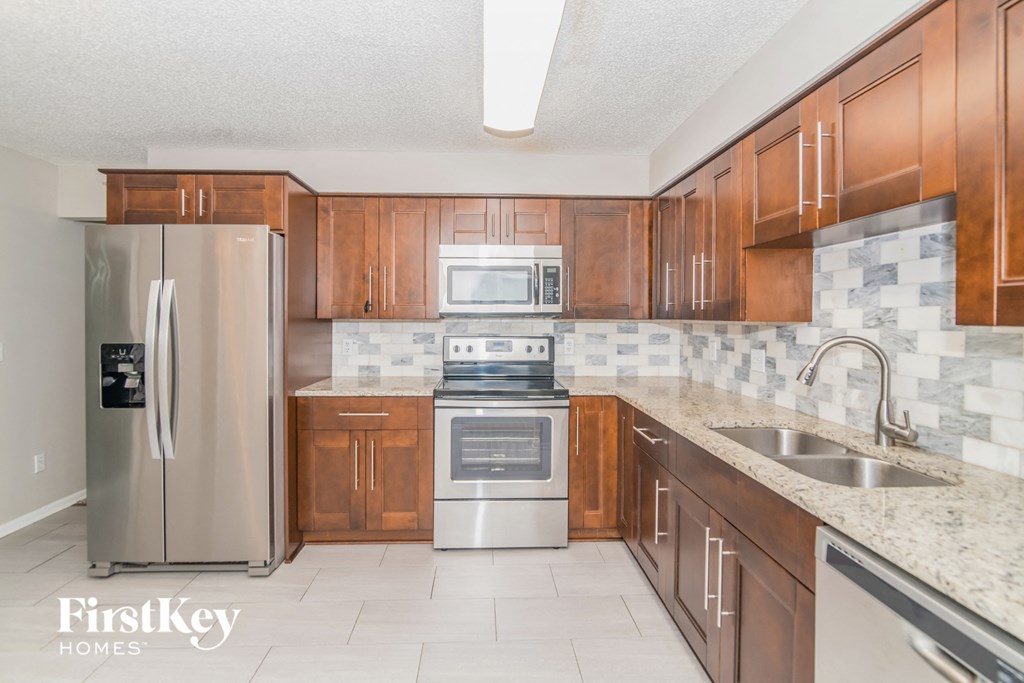 a kitchen with wooden cabinets and stainless steel appliances