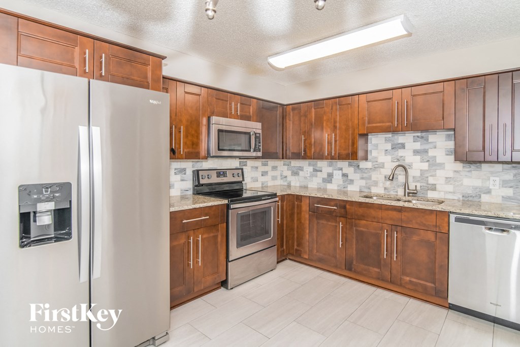 a kitchen with wooden cabinets and stainless steel appliances