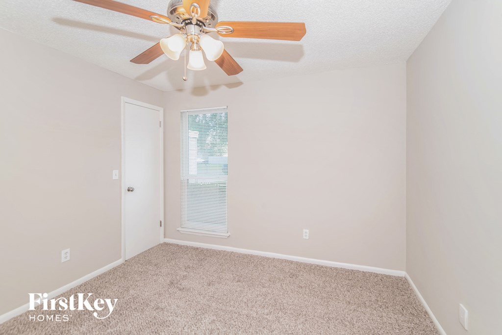 a bedroom with a ceiling fan and a window