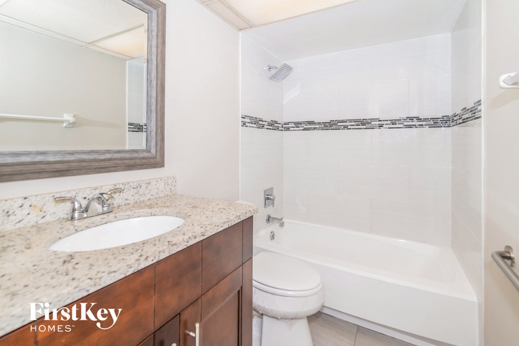 a bathroom with a sink toilet and tub and a mirror