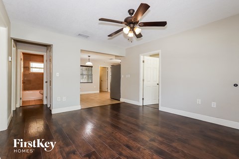 the living room and dining room with hardwood flooring and a ceiling fan