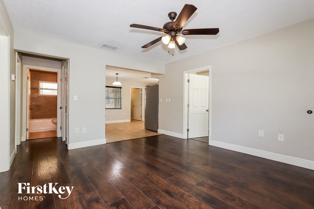 the living room and dining room with hardwood flooring and a ceiling fan