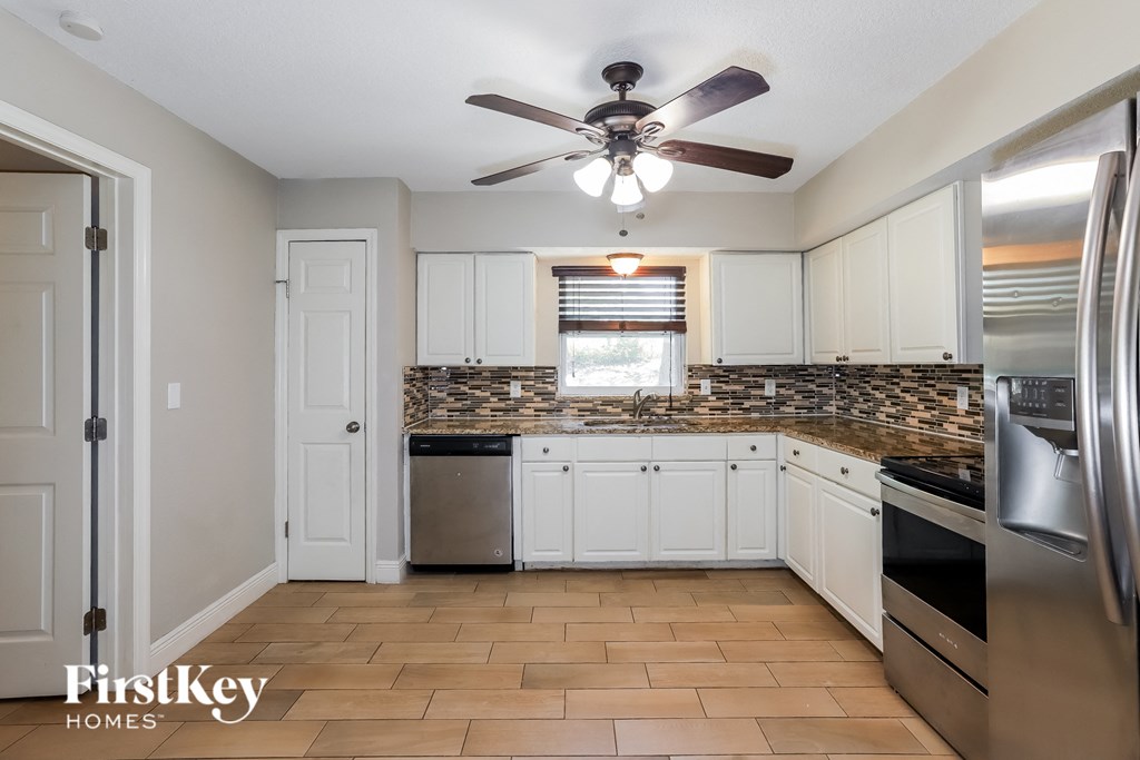 a kitchen with stainless steel appliances and a ceiling fan