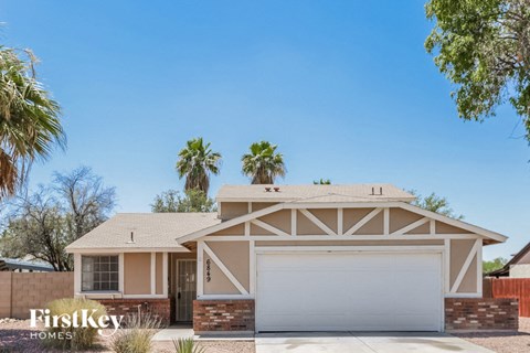 a house with a white garage door and palm trees
