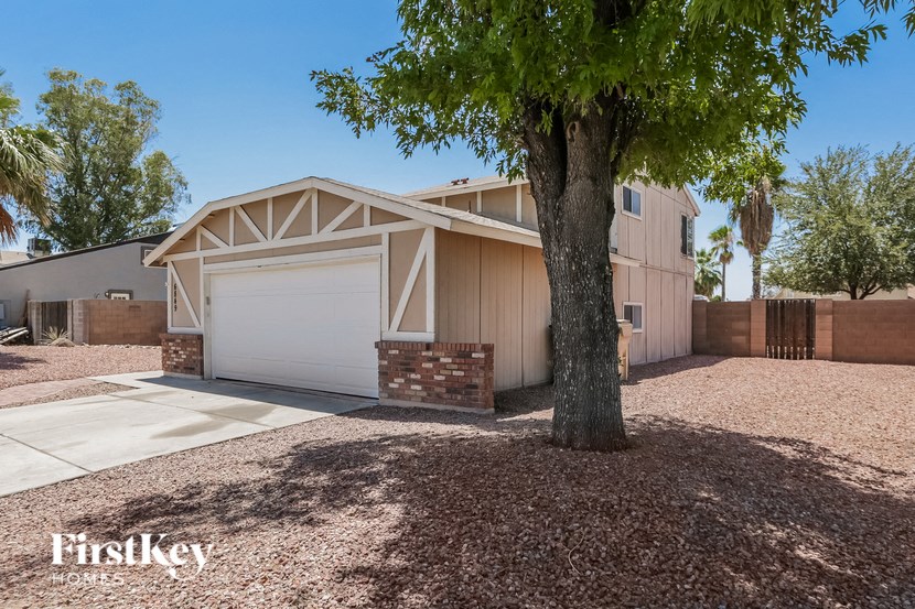 a house with a garage and a tree in front of it