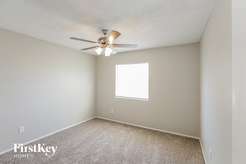a bedroom with a ceiling fan and a window