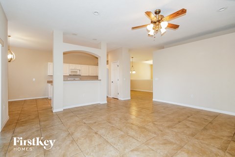 A spacious room with a ceiling fan and tiled flooring.