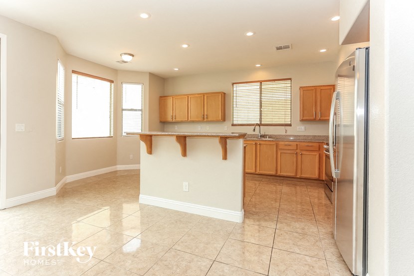 a kitchen with stainless steel appliances and wooden cabinets and tile flooring